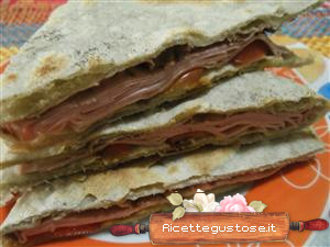 Piadina con pate di olive mortadella e pomodori ciliegino