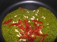 Tagliare i pomodori secchi e tostare i pinoli